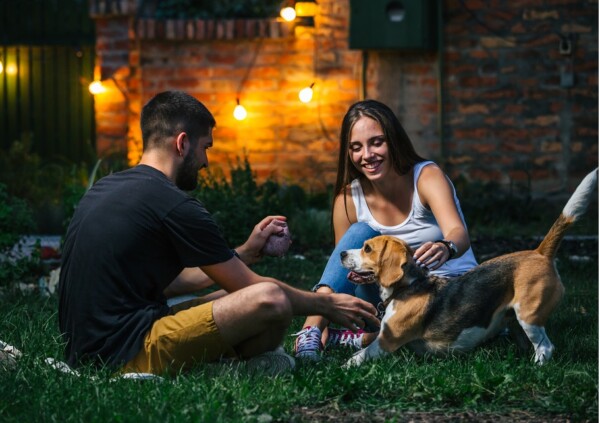 A couple outside with their dog at night